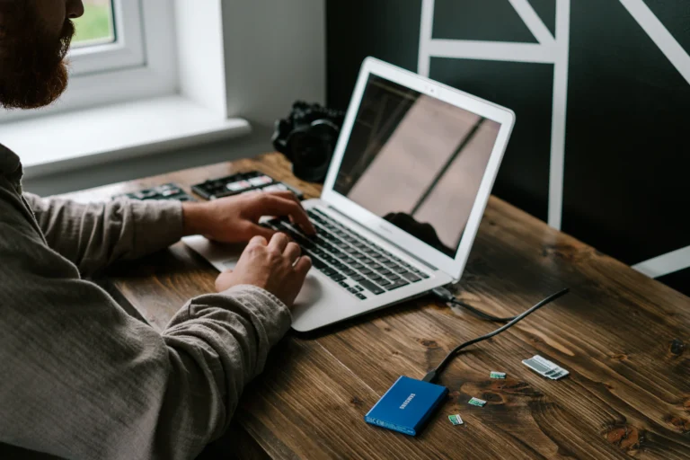 A person working at a laptop with portable storage