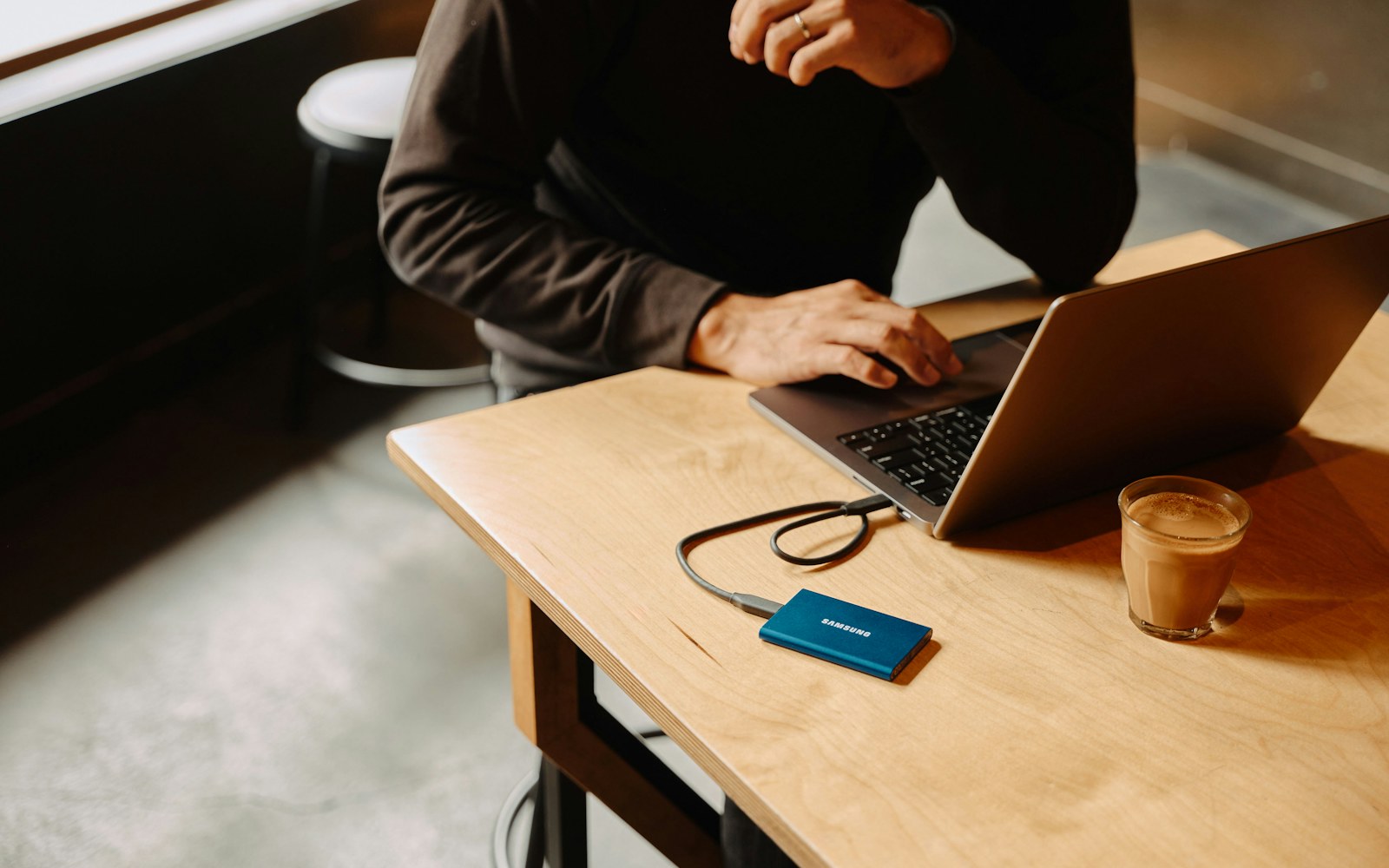 Person using a laptop at a desk while organizing files