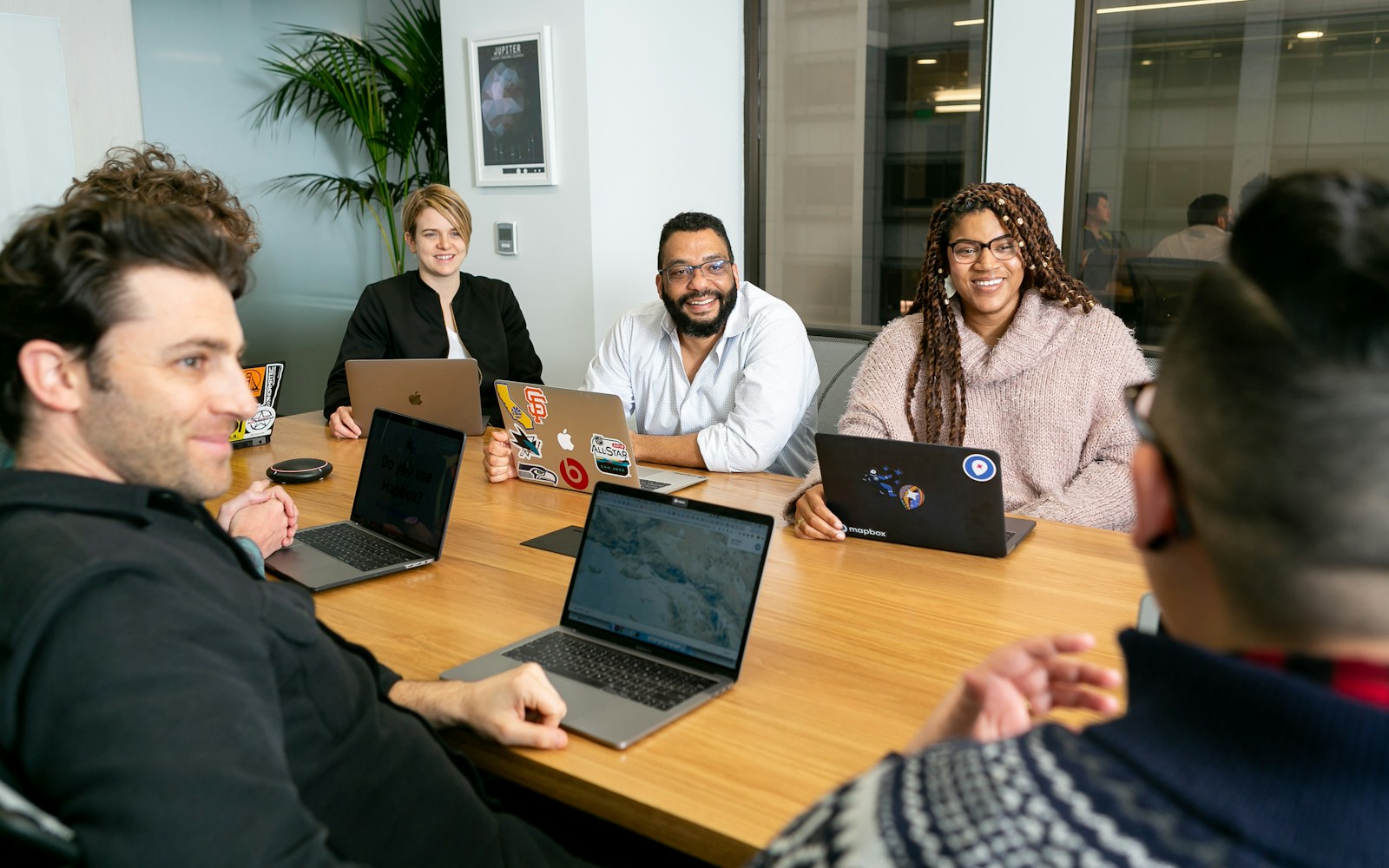 Colleagues discussing software work around a laptop