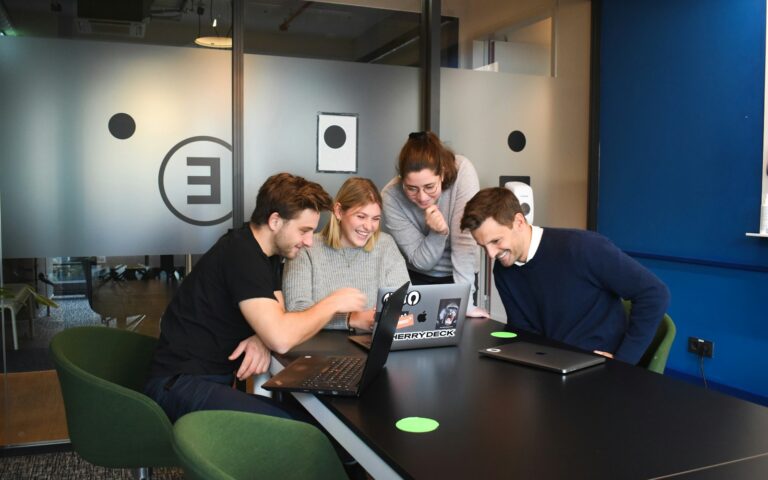 Small team seated together with laptop computers