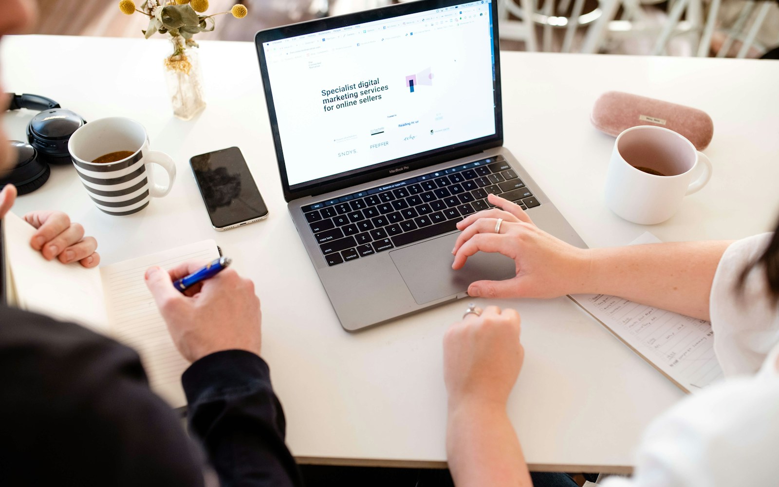 Two colleagues planning software costs at a desk
