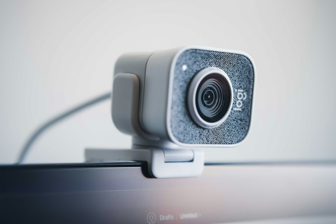 Webcam mounted on a monitor in a bright workspace
