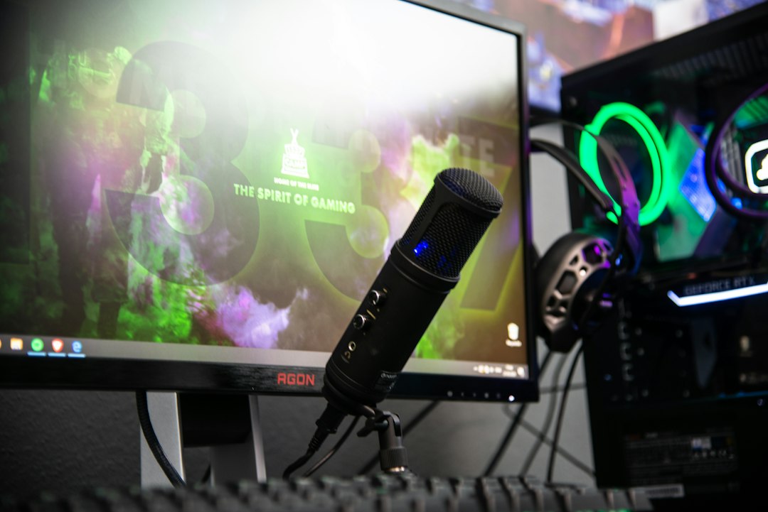 Microphone and headphones beside a gaming monitor