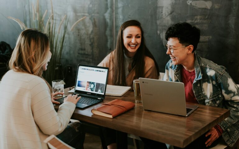 Team members reviewing information together on a laptop